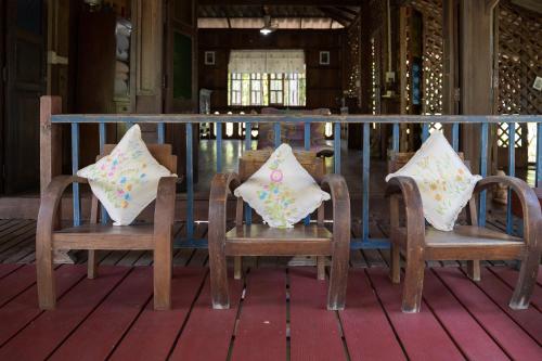 two chairs with pillows sitting on a porch at Art House at Chiangdao - Moon House in Chiang Dao