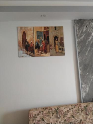 un quadro appeso al muro sopra il letto di سيسيليا اتش a Hurghada