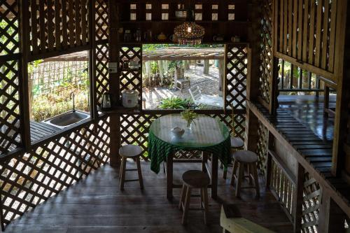 Aussicht von der Innenseite eines Hauses mit einem Tisch und Stühlen in der Unterkunft Art House at Chiangdao - Moon House in Chiang Dao
