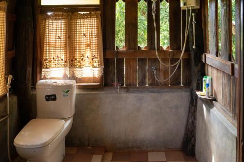 a bathroom with a toilet and a window at Art House at Chiangdao - Moon House in Chiang Dao