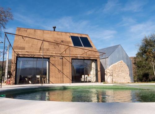 a brick house with a pool in front of it at GoToGeres - Casa da Cortiça - Sobrenatura in Arcos de Valdevez