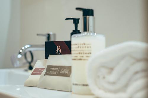 a bathroom with two bottles of soap and a sink at Palazzo Bellocchi - Suites & Apartments in Brindisi