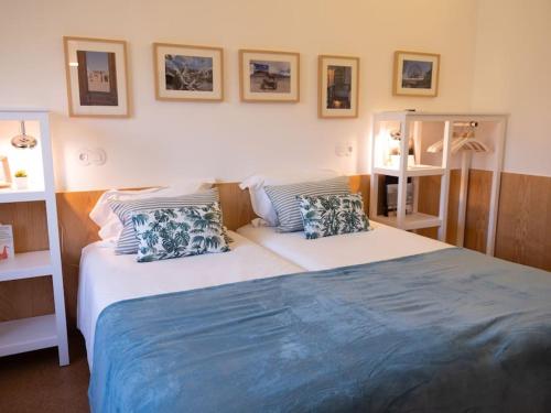 a bedroom with a large bed with blue sheets and pillows at GoToGeres - Casa da Cortiça - Sobrenatura in Arcos de Valdevez