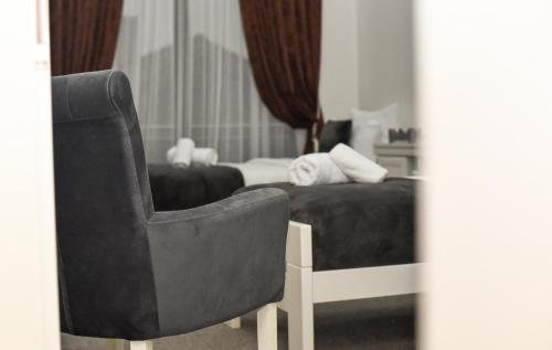 a black chair in a bedroom with a bed at Hotel PALACE in Velika Kladuša