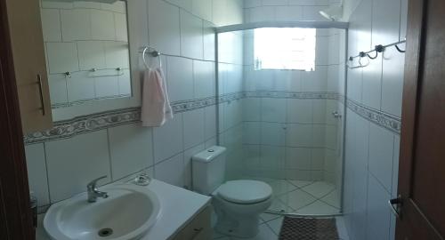 Baño blanco con aseo y lavamanos en Casa eco para você e seu pet!, en Canela