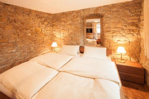 um quarto com uma cama numa parede de pedra em Ferienwohnung Pfaffenweiler em Pfaffenweiler