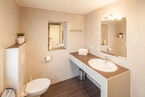 a white bathroom with a sink and a toilet at Ferienwohnung Pfaffenweiler in Pfaffenweiler