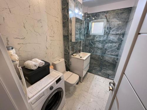 La salle de bains est pourvue d'un lave-linge et d'un sèche-linge. dans l'établissement Aparthotel Junior4 Cluj, à Cluj-Napoca