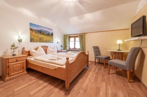 Schlafzimmer mit einem Bett, einem TV und einem Tisch in der Unterkunft Landhotel Gasthof Stern in Gößweinstein