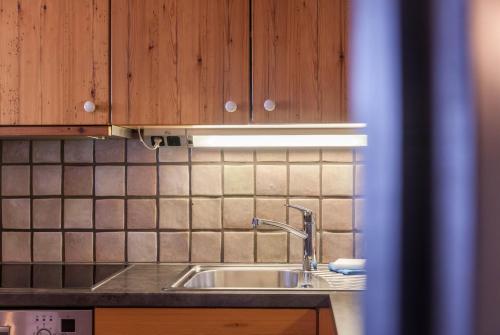 La cuisine est équipée d'un évier et de placards en bois. dans l'établissement Haus Excelsior Top 37b, à Seefeld in Tirol