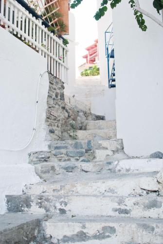 a set of stone stairs leading up to a white building at Pantheon Studios in Léntas