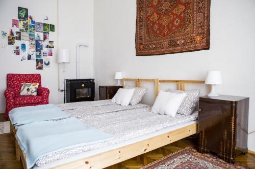 ブダペストにあるSipi Apartmanのベッドルーム1室(ベッド1台、赤い椅子付)
