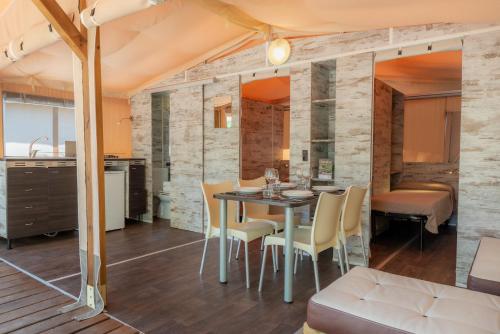 a kitchen and dining room with a table and chairs at Camping Village Rocchette in Castiglione della Pescaia