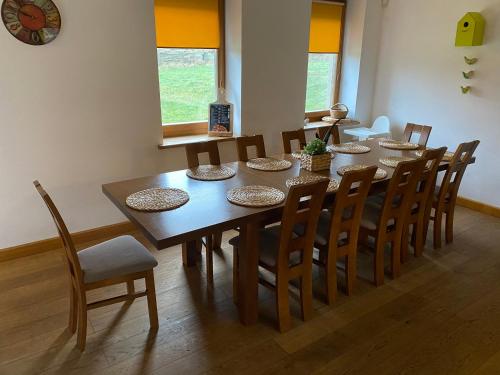 Siedlisko na Wzgórzu في Wizna: غرفة طعام مع طاولة وكراسي
