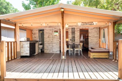a wooden deck with a tent on it at Camping Village Rocchette in Castiglione della Pescaia