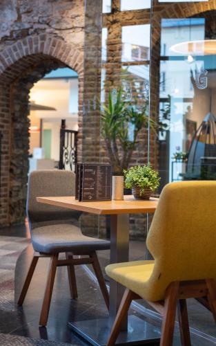 a table and two chairs in a room at Novotel Gent Centrum in Ghent