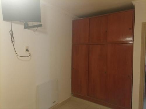 Habitación con armario de madera y luz. en CONFORTABLE DUPLEX CON GARAGE en Santiago del Estero