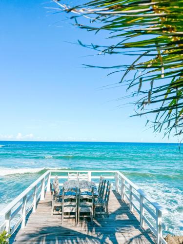 a table and chairs sitting on a pier on the beach at Peninsula Esmeralda Luxury Villas in San Felipe de Puerto Plata