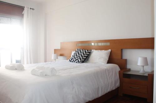 um quarto com uma grande cama branca com toalhas em Global Guest Massama em Queluz