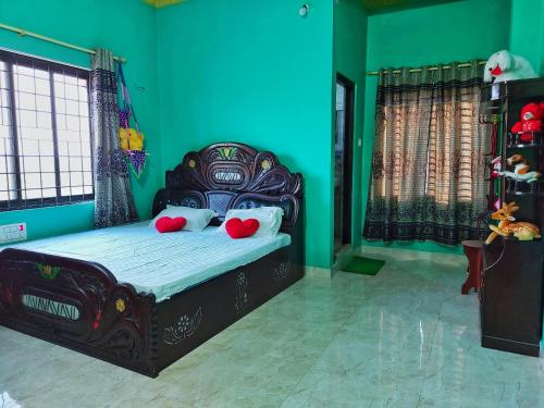 a bedroom with a black bed with red pillows at Tathāgata Homestay in Lumbini