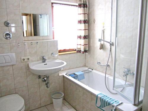 łazienka z umywalką, wanną i toaletą w obiekcie Ferienwohnung Haus Jennerwein w mieście Sachrang