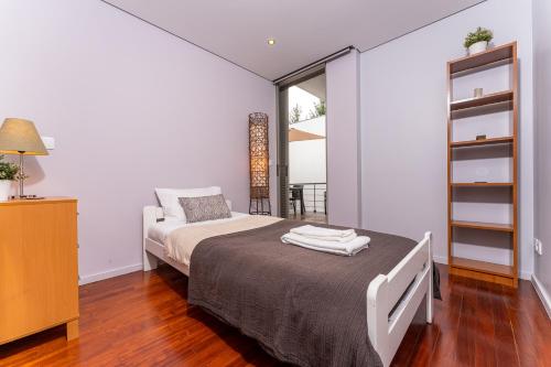 a small bedroom with a bed and a window at Golf Course - Luxurious Flat T3 - Ponte de Lima in Ponte de Lima