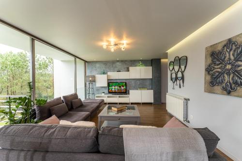 a living room with a couch and a tv at Golf Course - Luxurious Flat T3 - Ponte de Lima in Ponte de Lima