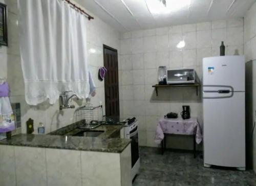 uma cozinha com um frigorífico branco e um lavatório em Imperdível - Casa aconchegante com varanda em Ouro Preto