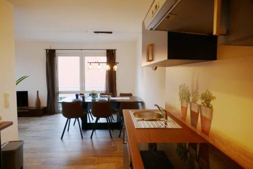 a kitchen and dining room with a table and a sink at Ferienwohnungen Brombachsee in Pleinfeld