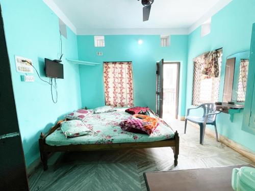 a bedroom with a bed with blue walls at Radha Krishna Holiday Home in Puri