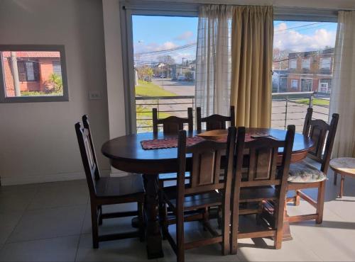 een eetkamer met een tafel en stoelen en een raam bij Wenuray MdQ in Mar del Plata