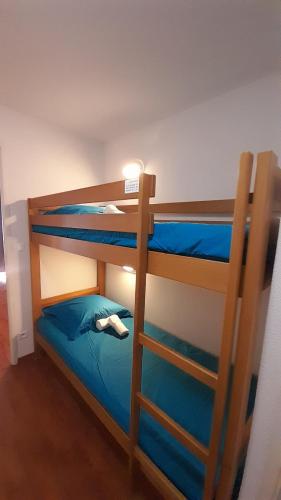 a bedroom with two bunk beds with blue sheets at Chez Lulilo in Ax-les-Thermes