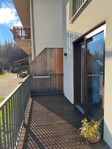 a balcony of a house with a sliding glass door at Pension & Apartments Waldkrieber in Presseggersee