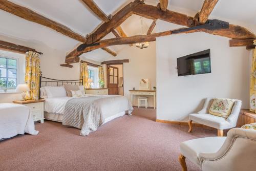 a bedroom with a large bed and a chair at farmhouse cottage in Keswick