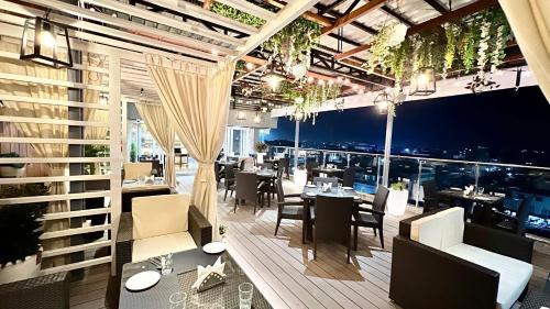 a restaurant with tables and chairs and a view of the city at Aurora Boutique Hotel Imphal in Imphal