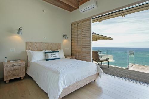a bedroom with a bed and a view of the ocean at Beach Music in Llandudno