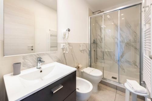 a bathroom with a sink and a shower and a toilet at Alla Casa Rosa al Mare, Central Seafront Stay, Air Conditioning, Wi-Fi, the Ideal Choice for a Relaxing and Exciting Coastal Escape, with available on request at 20,00 euro per night Private Garage, Welcome kit Priority, Prosecco and Canestrelli in Rapallo