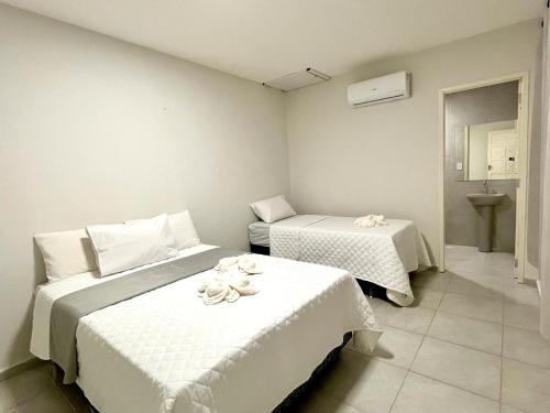 a bedroom with two beds with towels on them at Casa em Porto de Galinhas by AFT in Porto De Galinhas