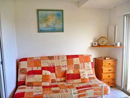 - un salon avec un canapé et une couverture dans l'établissement Studio cabine cosy avec terrasse, accès direct plage et parking privé, 2-4 pers, animaux ok - FR-1-387-139, à Marseillan