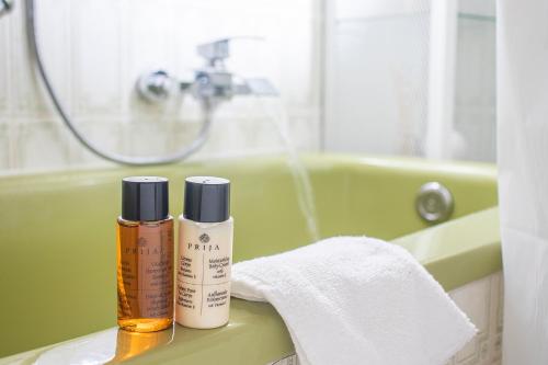 a bathroom with two bottles of essential oils and a bath tub at BlackNCozy - Großzügiges Designappartement mit Boxspringbetten und Heimkino in Feldberg