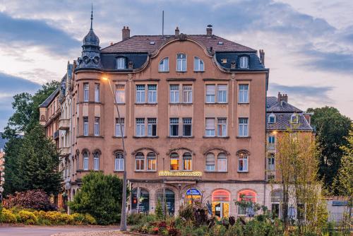 a large brick building in front of a street at Hôtel Le Mondon Metz in Metz