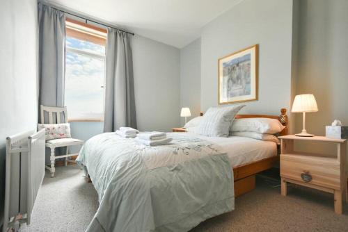 a bedroom with a large bed and a window at Rosedale House in Amble