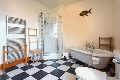 a bathroom with a tub and a toilet and a shower at Rosedale House in Amble