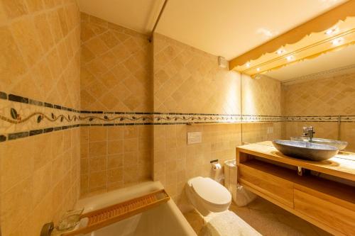 ein Badezimmer mit einem Waschbecken, einer Badewanne und einem WC in der Unterkunft Chalet Ciel de Lit in Nendaz