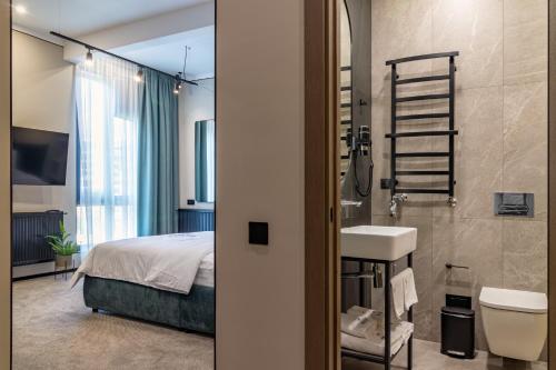 a bathroom with a bed and a sink and a shower at Shelter Apart Hotel in Bukovel