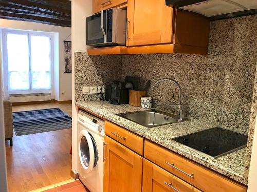 a kitchen with a sink and a washing machine at L'appartement Vaugirard in Paris