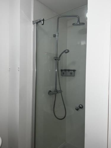 a shower in a bathroom with a glass door at Modern Studio in popular South Kensington location in London