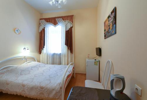 a small bedroom with a bed and a window at Harmony in Cherepovets