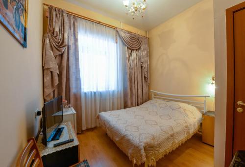 Habitación pequeña con cama y ventana en Harmony, en Cherepovets
