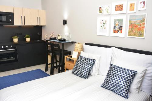 um quarto com uma cama com almofadas e uma cozinha em Casa Bacsó em Budapeste